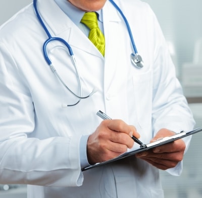 Doctor with a yellow tie and a clipboard that has COVID-19 on it