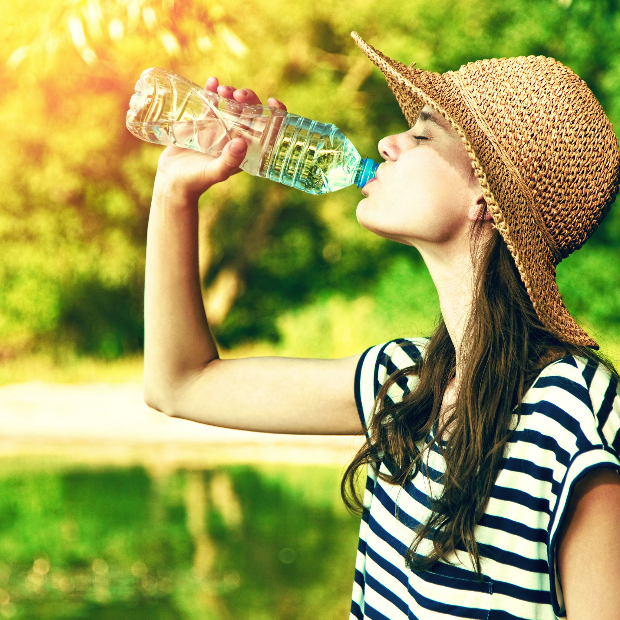 Woman drinking water in the summer heat.